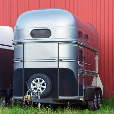 Several horse transportation trailers parked on the grass Picture of Several horse transportation trailers parked on the grass in front of red painted wooden house